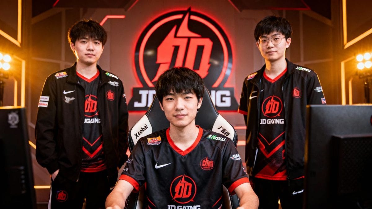 JD Gaming coaches [Tabe], [Xiaobai], and player [Xiaoxu] in team jerseys.